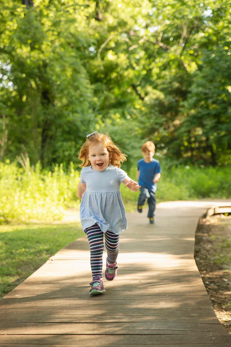 Two young kids running during a candid fall family session in Dallas
