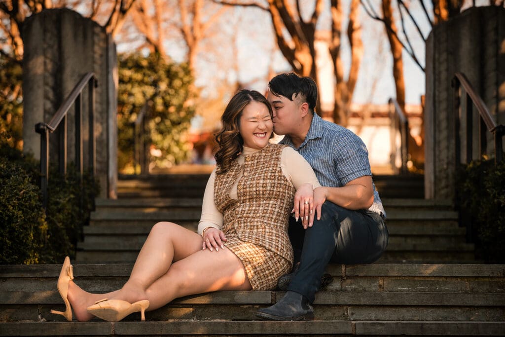 Newly engaged couple sitting on stone steps at the Dallas Arboretum for an editorial engagement portrait session.