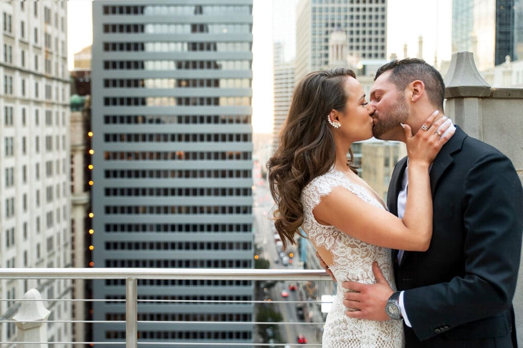 Bride and groom sharing a kiss on the glass balcony of The Joule hotel in Dallas.

Description: Real emotion, zero forced staging.