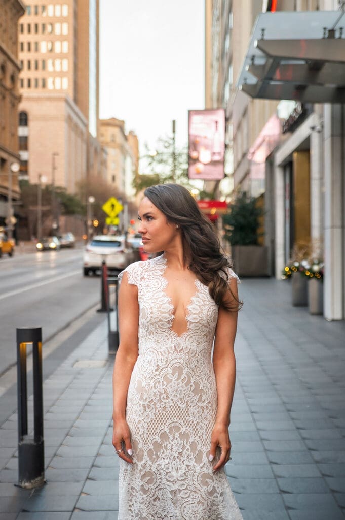 Bride in a lace wedding dress walking down Main Street outside The Joule in Dallas, Texas.