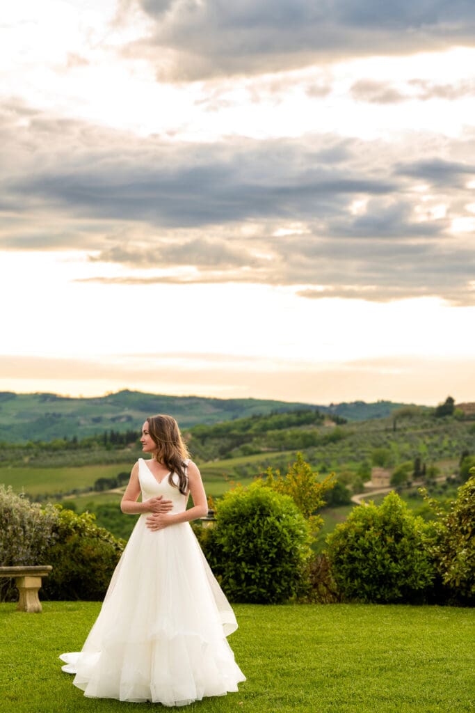 An elegant, editorial bridal portrait captured during golden hour overlooking the sweeping Tuscan landscape.